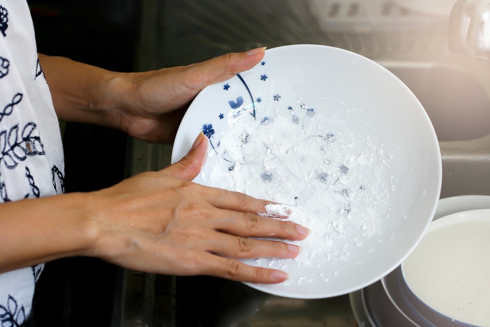 A view of a person holding a plate with a powder mixture