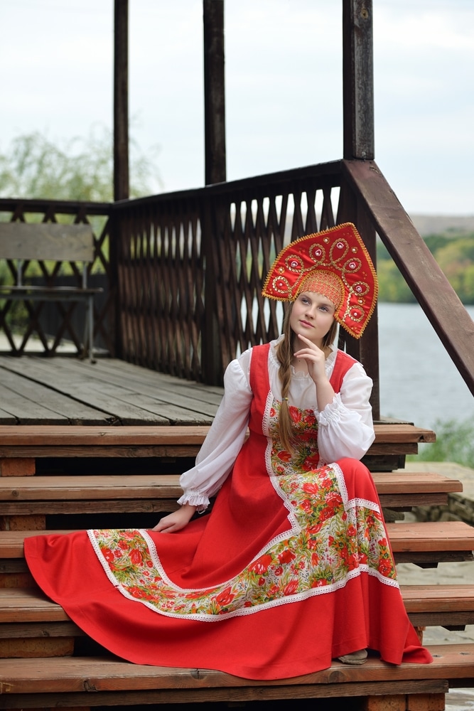 A view of a woman sitting wearing russian clothing