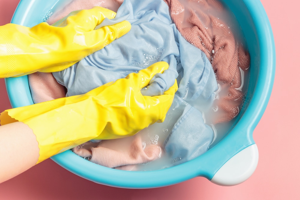 A view of gloved hands washing clothes