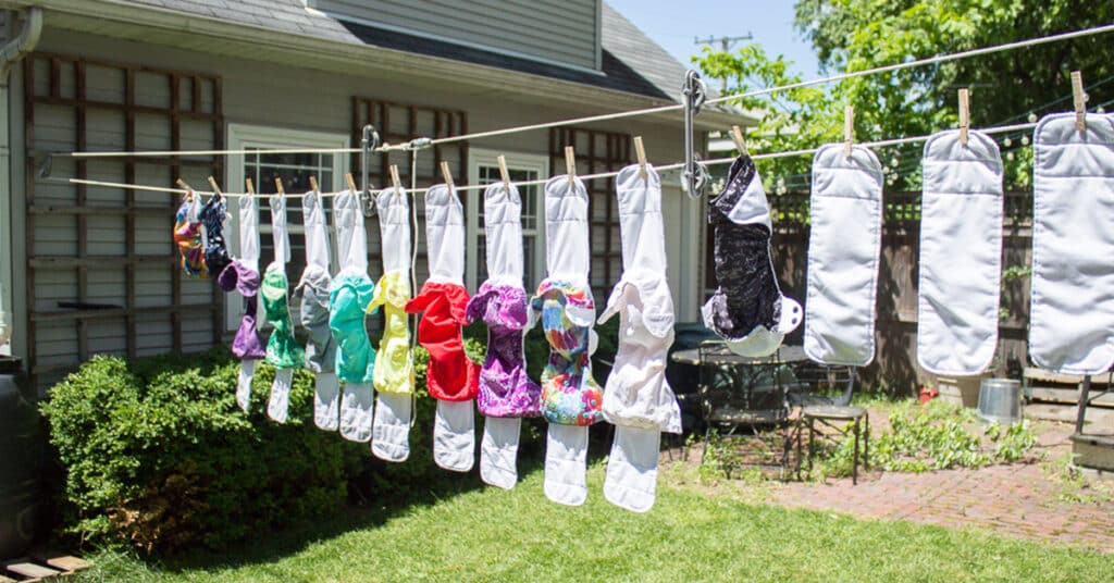 A DIY pulley clotheseline outside a house with clothes hanging to dry