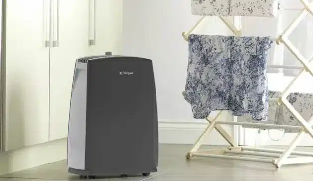 A dehumidifier beside a clothes drying rack