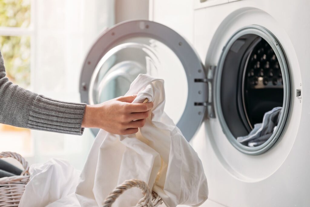 A hand taking clothes out of a tumble dryer