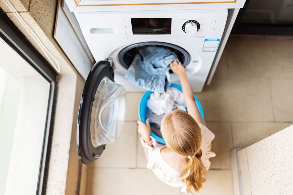 A top view of a woman taking clothes out of a tumble dryer