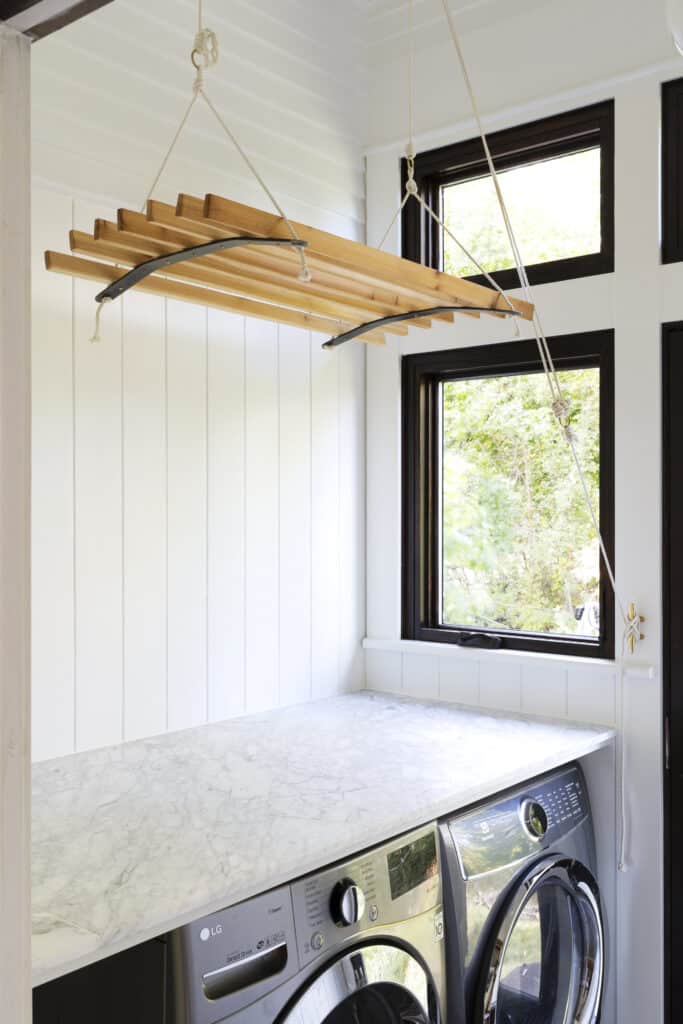 A ventilated hanging clothes drying rack with a window by side