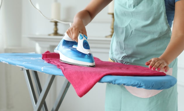 A woman ironing clothes to dry