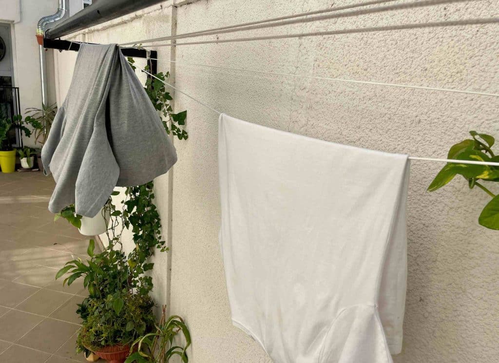 Clothes drying out on a clothesline in back laundry space of home