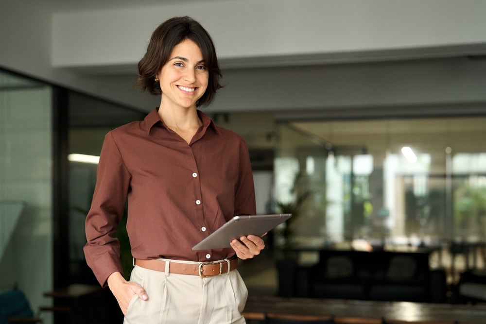 Portrait Of Young Hispanic Professional Business Woman Standing In Office