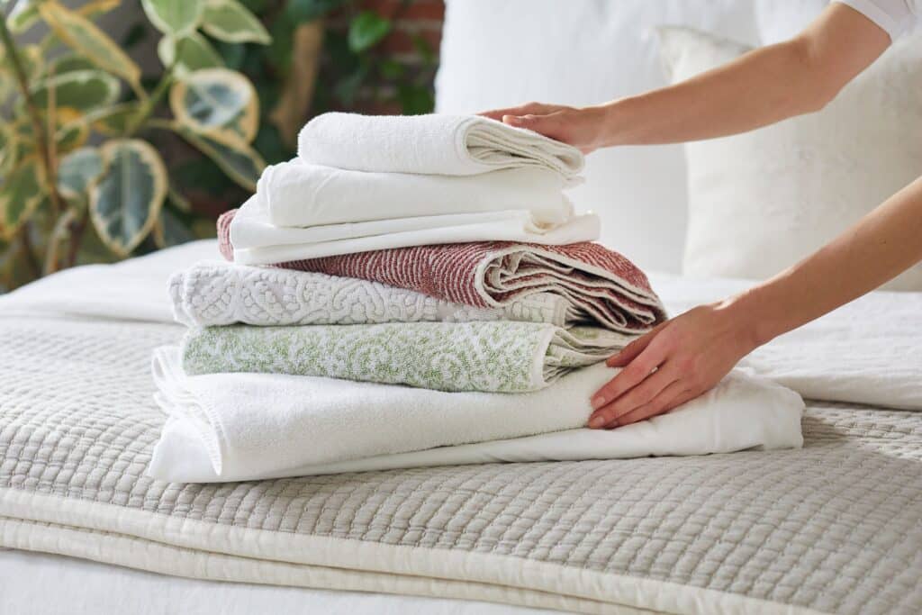 Two hands on a bunch of folded towels