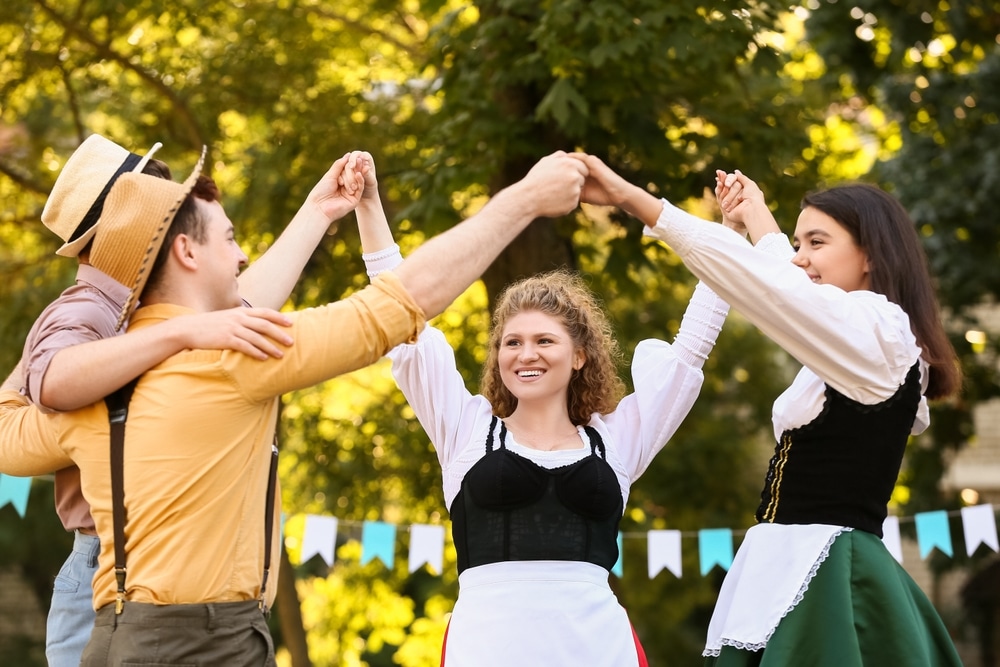 Young People In Traditional German Clothes Dancing Outdoors Octoberfest Celebration