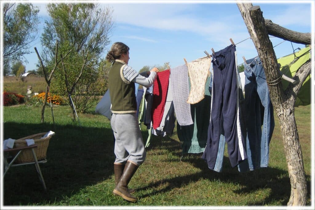 a lady hanging clothes in the outdoor space in garden