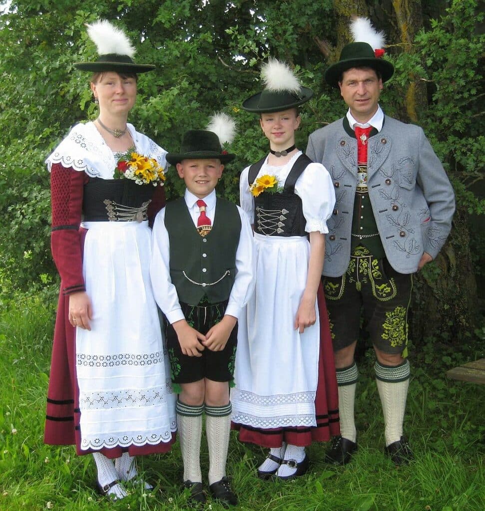 a picture of family wearing german costume women wearing dirndl with hats men wearing lederhosen