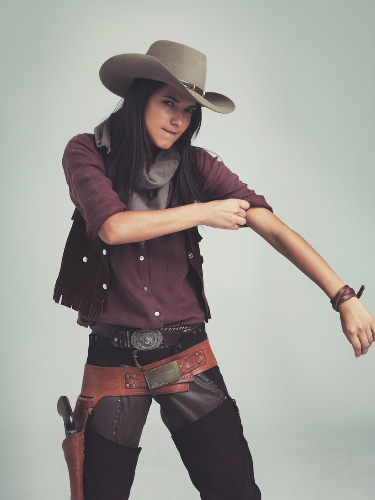 cowgirl dressed up with leather belt and bucket, sleeves rolling up