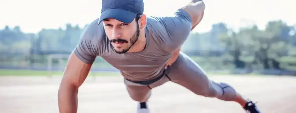 A view of a guy doing pushups wearing grey polyester gym clothes