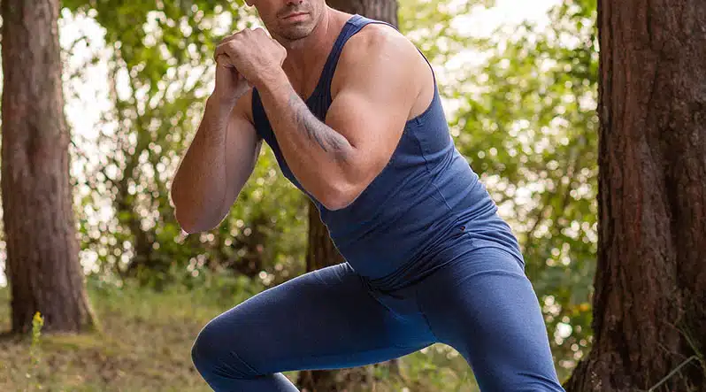 A view of a guy flexing in blue gym merino attire