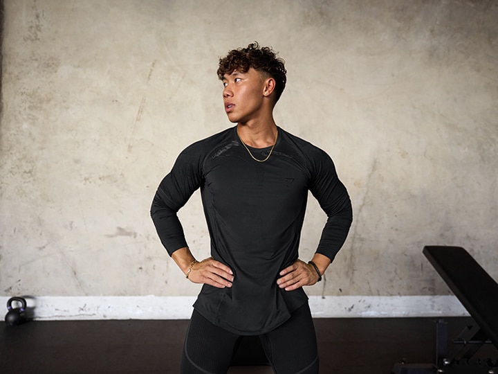 A view of a guy looking sideways wearing a black elastane gym outfit