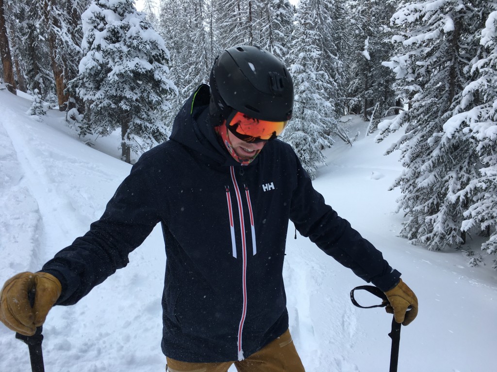 A view of a person skiing in snow wearing a Helley Hansen Ski jacket