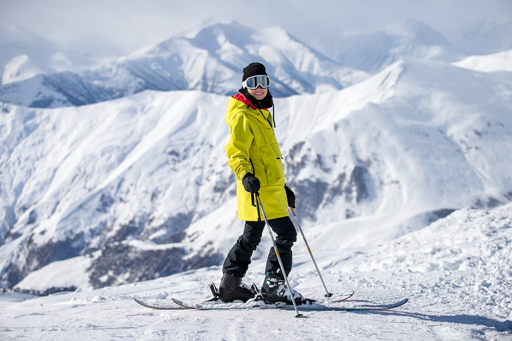 A view of a woman standing in snow with a ski stick