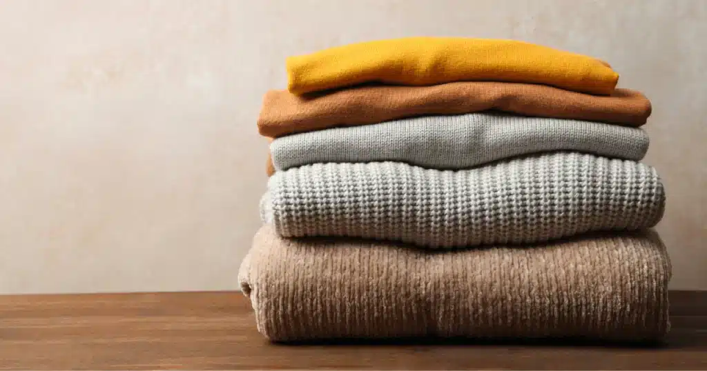 stacked wool sweaters on a table