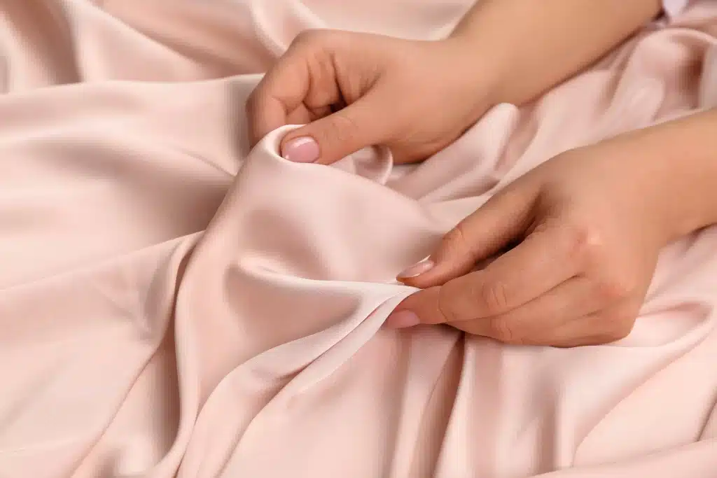 women is holding a silk fibre in her hands