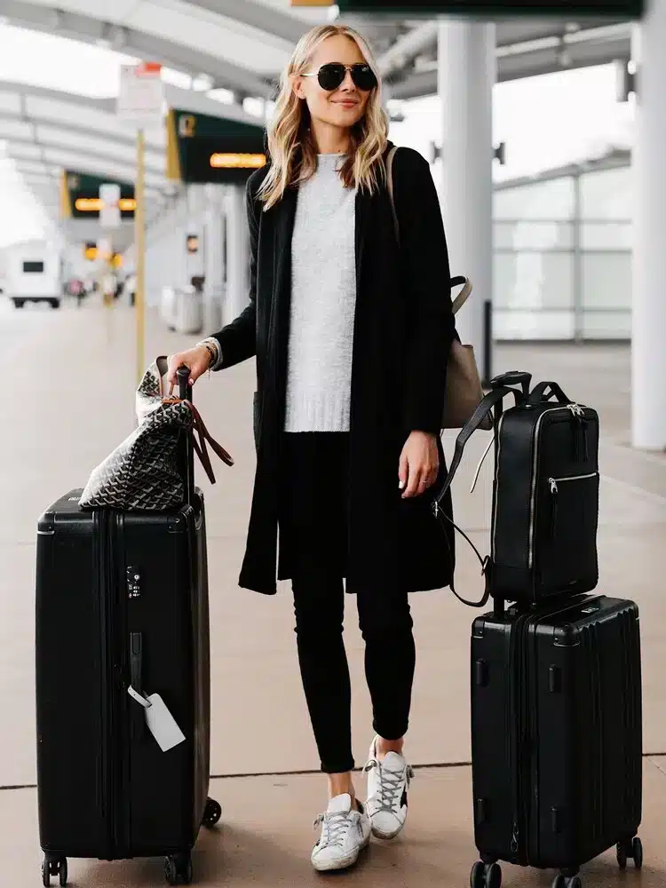 women standing along with suitcases and backpack on her back