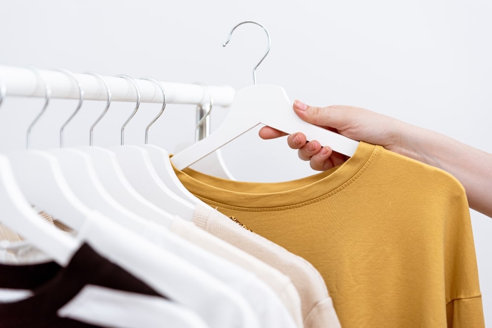 Woman Hand Picking Out Clothes To Buy Hanging On Clothing