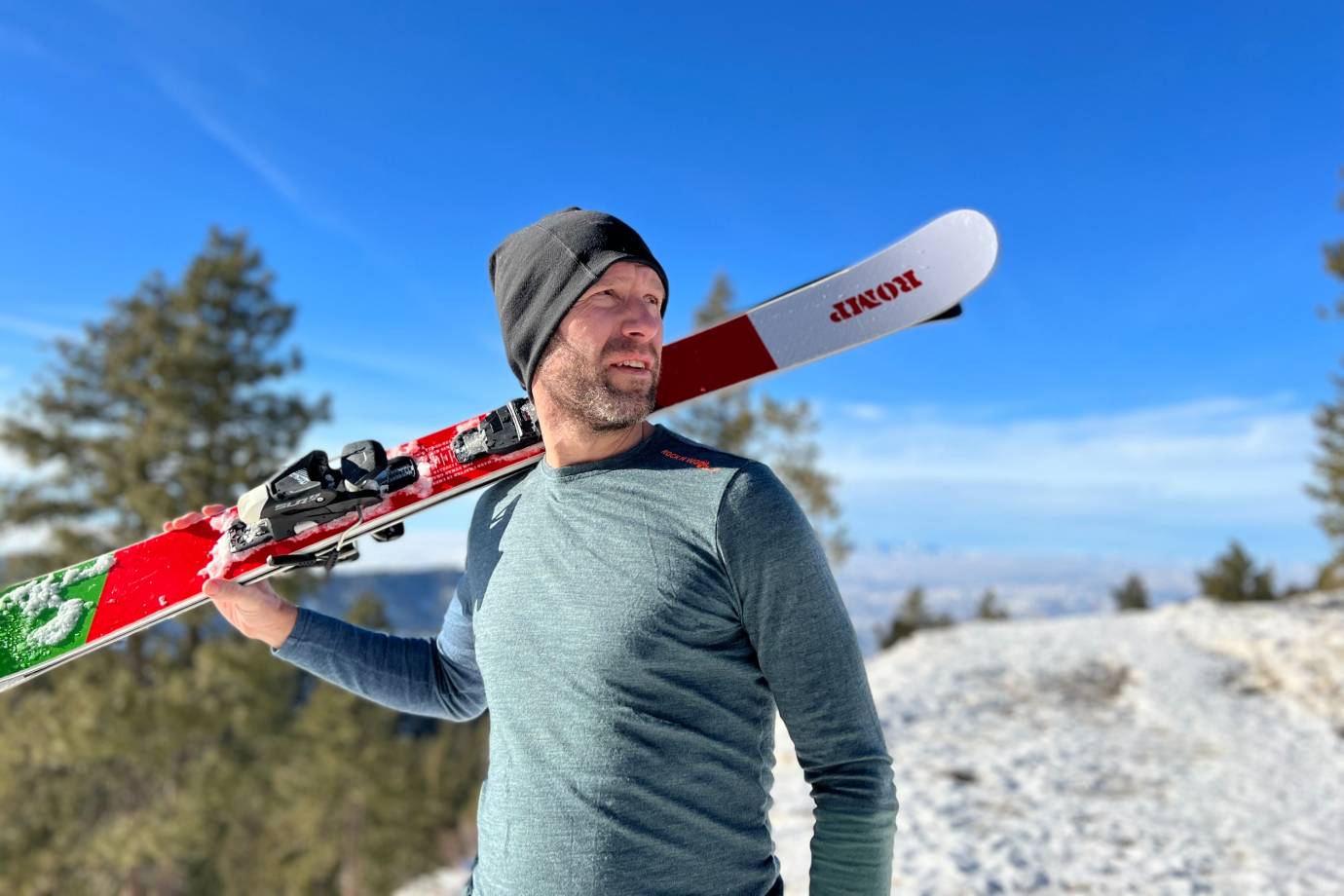 a man carrying a skate board wearing base layers