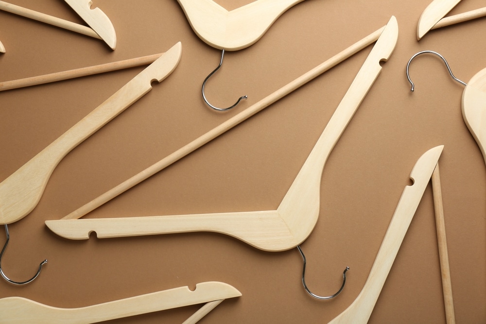 Wooden Hangers On Brown Background Flat Lay