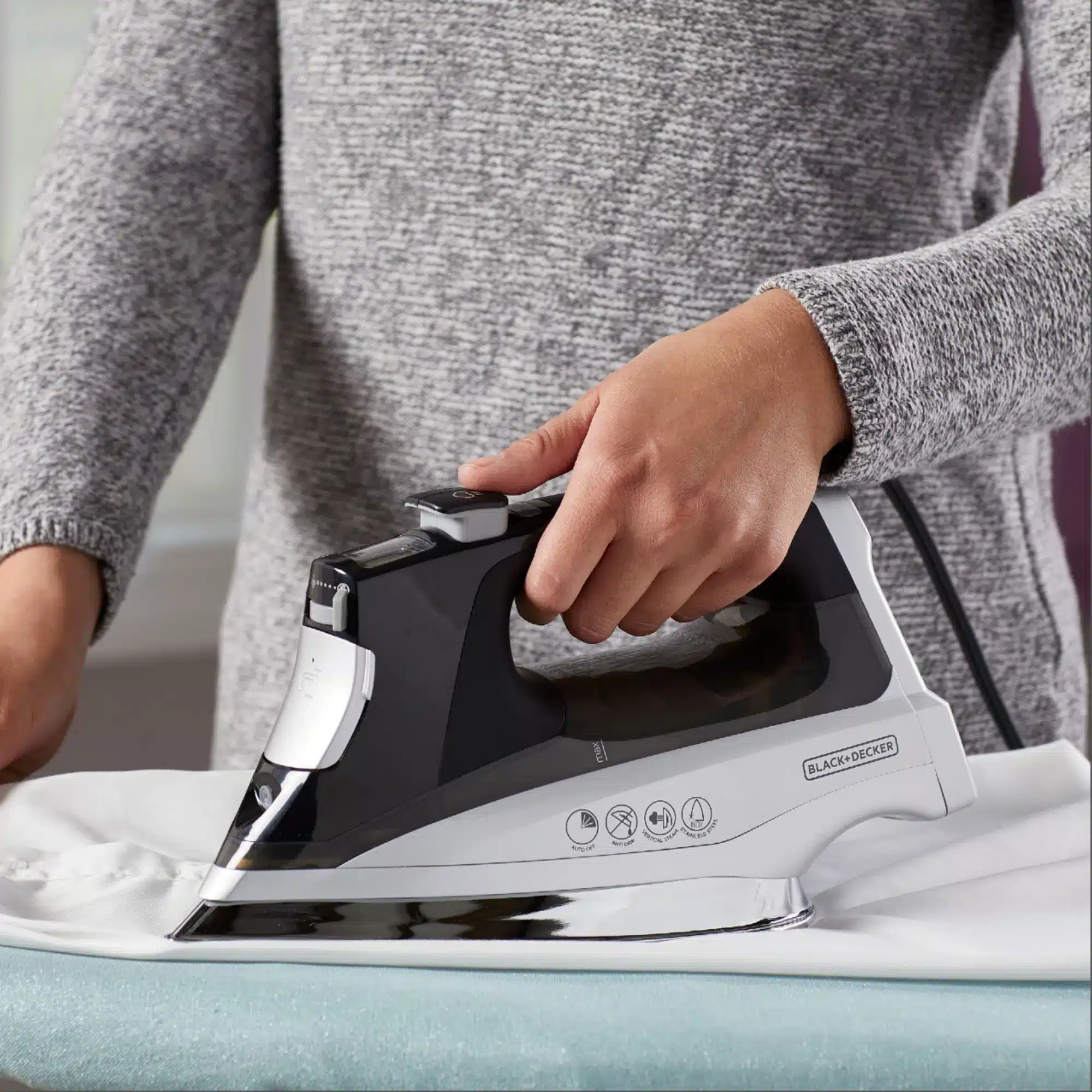 womne is pressing the clothes with Black+Decker D Allure Professional Steam Iron